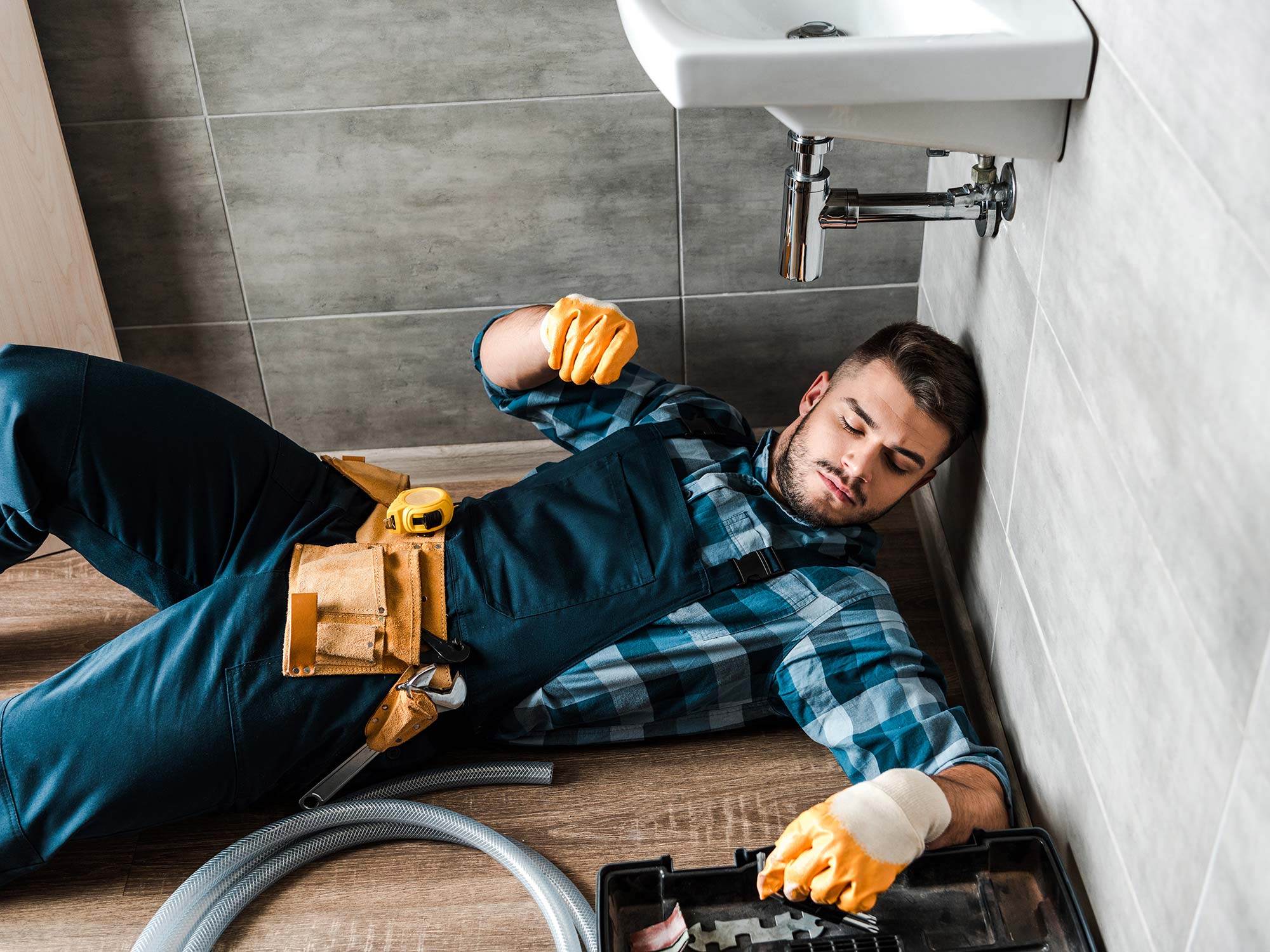 bearded-handyman-lying-on-floor-near-toolbox-in-ba-resize.jpg